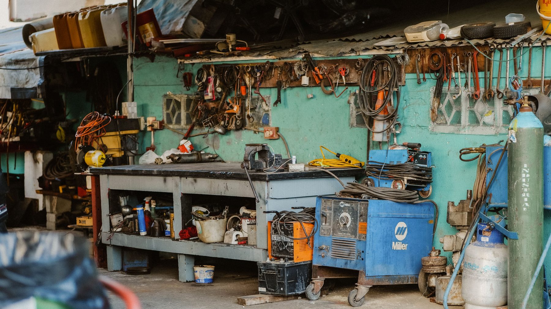 A cluttered, well-used workbench in a working garage