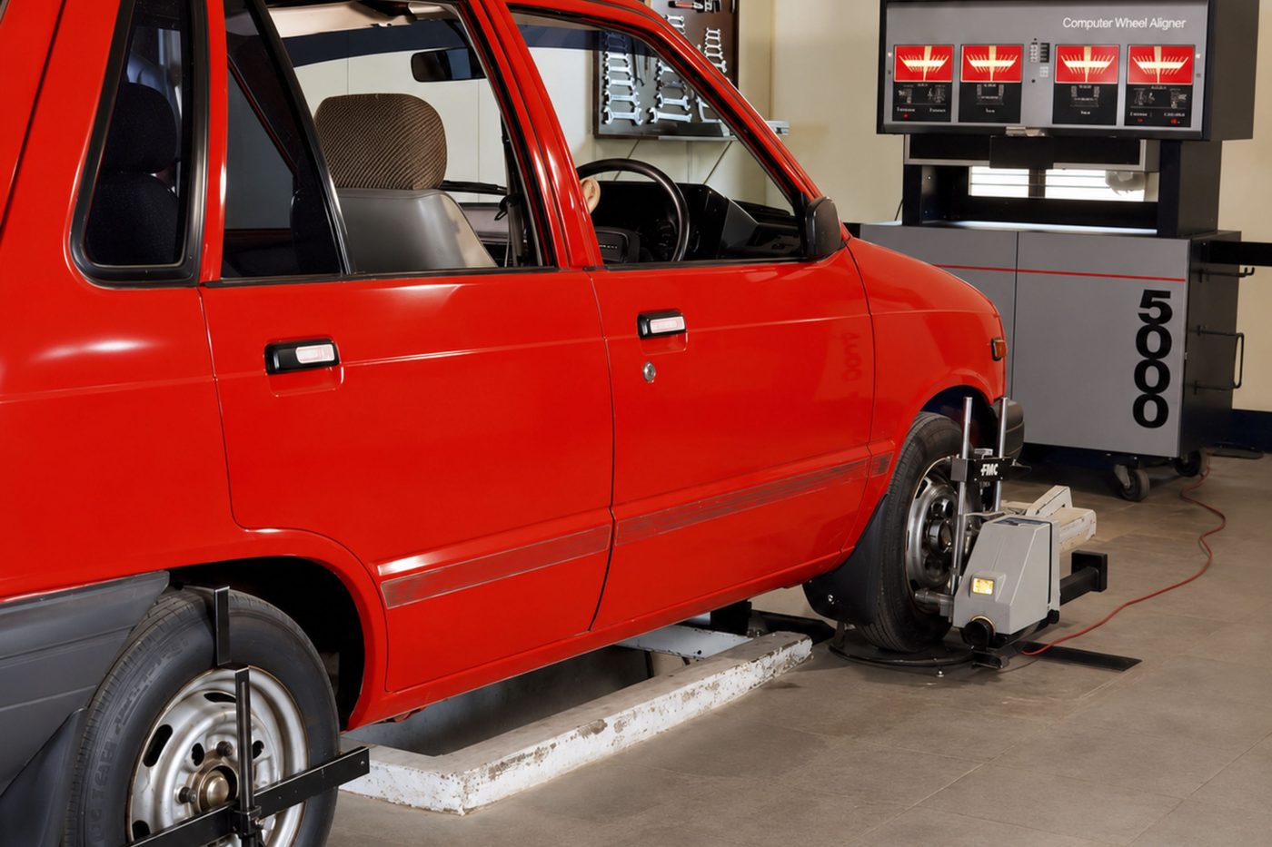 A car on an alignment rig with measurement screens